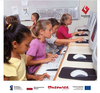zdjęcie przedstawia dziewczęta pracujące przy komputerach w pracowni komputerowej