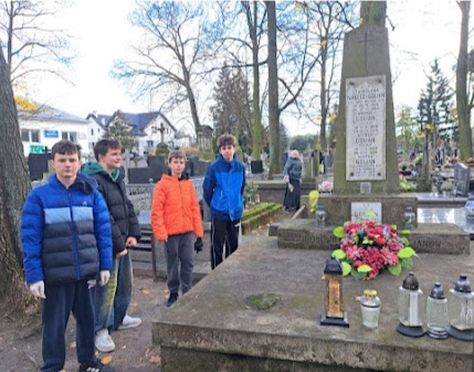 uczniowie z wolontariatu w czasie akcji sprzątania grobów