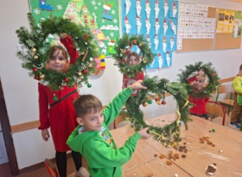 warsztaty świąteczne w 1c - dzieci z własnoręcznie zrobionymi wieńcami bożonarodzeniowymi