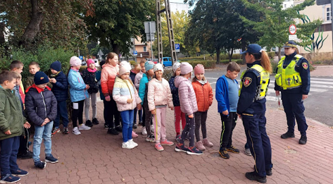 Grupa dzieci na skrzyżowaniu ulic w ramach akcji Bezpieczna droga do szkoły ze Strażą Miejską