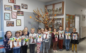 Grupa przedszkolaków ze swoimi pracami plastycznymi na okoliczność Dnia Drzewa